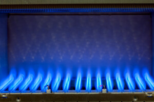 Natural gas burning inside a heat exchanger inside a gas-powered furnace