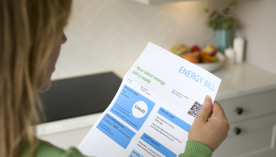A woman reads her electricity bill