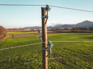 Close up of an electrical tower with electrical wire running to and from it