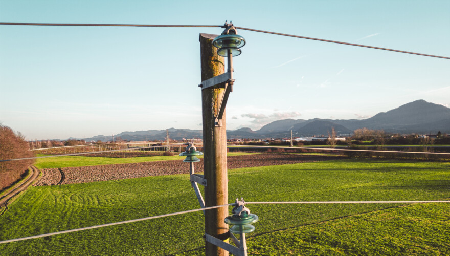 Close up of an electrical tower with electrical wire running to and from it