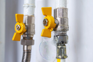 A pair of gas pipes with air bubbles on their surface due to a natural gas leak