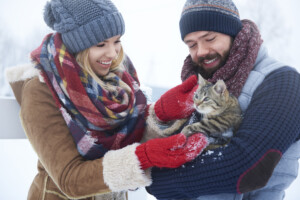 Happy couple with cat in winter day