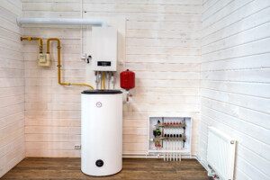 A water heater in a utility room with white, wooden walls