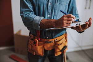 Close up of a repairman standing and making notes