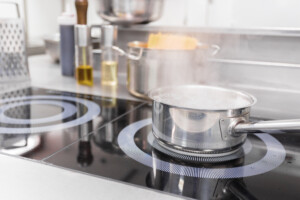A pot of boiling water sits on an electric stove while steam rises, indicating boiling pasta.