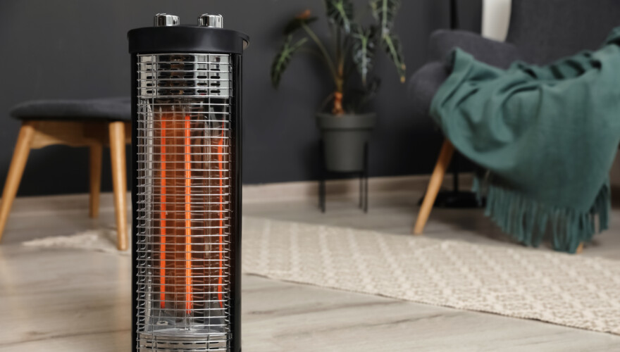 Modern electric halogen heater on floor in room interior