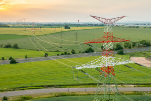 Aerial view of electric power transmission lines at sunset.
