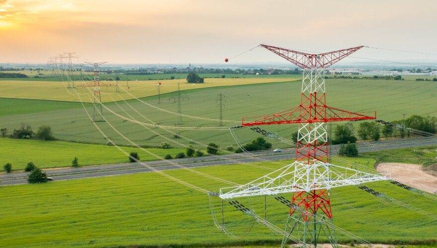 Aerial view of electric power transmission lines at sunset.