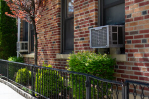 Outdoor Window Air Conditioning Units on an Old Brick Apartment Building during Spring