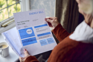 Close Up Of Senior Woman Opening an Energy Bill