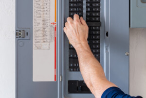 Homeowner resetting tripped breakers on electrical panel